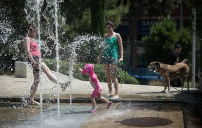 A family plays in a water fountain in Barcelona