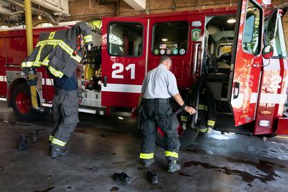 Firefighter Rod MacKinnon, left, and Lt. Chris Stevens don their turnout gear as they respond to a call at the Engine 21 fire station, Thursday, Aug. 24, 2023