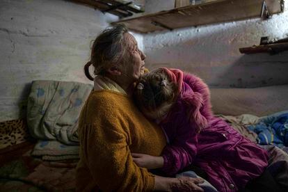 Khrystyna hugs her grandmother Liubov as they take cover at the basement of their house during the shelling in Bohoyavlenka, Ukraine, on Sunday, April 9, 2023.