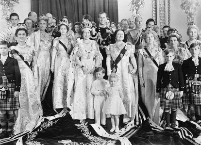 A smiling Queen Elizabeth poses with her family and members of the royal family in the throne room at Buckingham Palace, after her coronation. In front are the Queen's two children, Prince Charles and Princess Anne, while behind her is her husband, the Duke of Edinburgh. At her right is her sister Princess Margaret, while at her left is the Queen Mother.