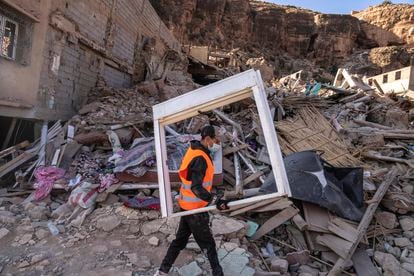 A volunteer helps salvage furniture from homes which were damaged by the earthquake, in the town of Imi N'tala, outside Marrakech, Morocco, Wednesday, Sept. 13, 2023