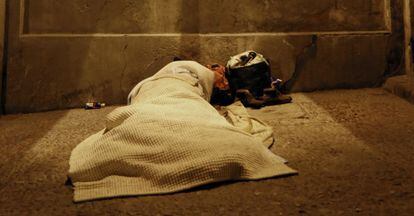 A man spends the night under the viaduct that crosses Segovia street.