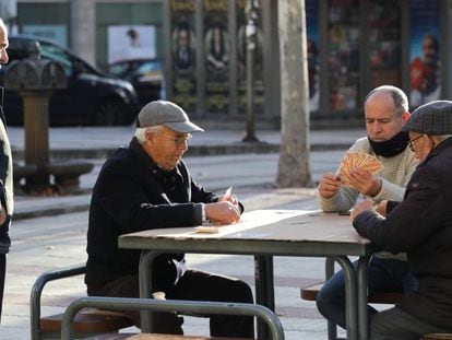 A group of men play cards in a street in Madrid.