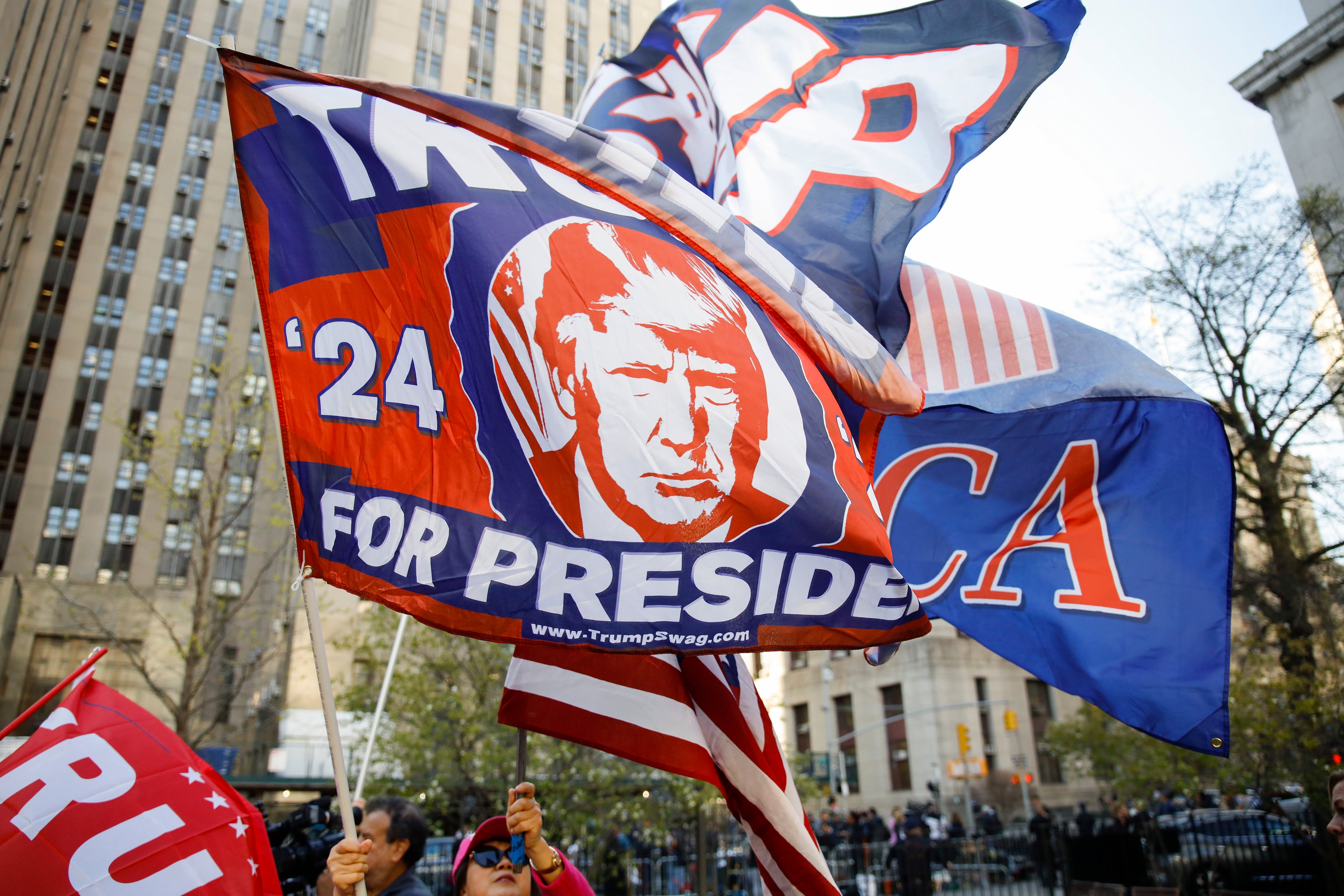 Donald Trump’s supporters display banners of support in front of the Manhattan courthouse on Monday.