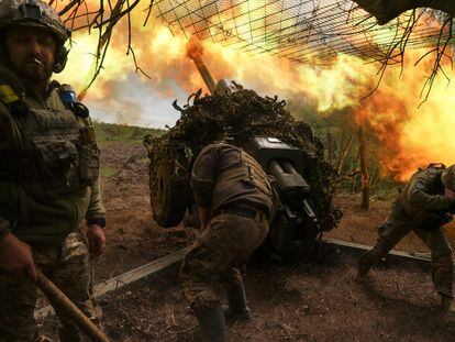 Three Ukrainian servicemen fire a shell in the Donetsk region on Saturday, May 6.