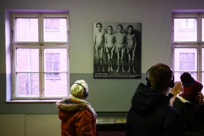 Visitors to the Auschwitz Memorial look at a photograph with some of the children who were subjected to Dr. Josef Mengele’s experiments.