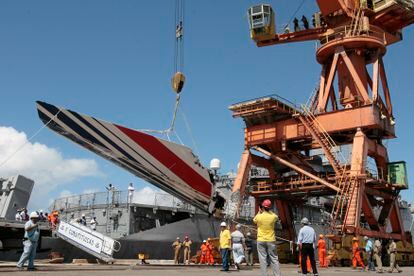 Workers unloading debris, belonging to crashed Air France flight AF447, from the Brazilian Navy's Constitution Frigate in the port of Recife, northeast of Brazil, Sunday, June 14, 2009