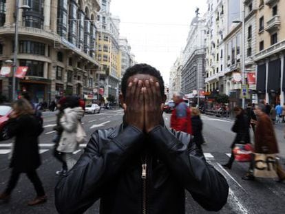 Yafar shields his face on a Madrid street.