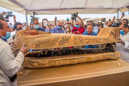 Egyptologists opening a sarcophagus at the necropolis                of Sakkara, Egypt, in October 2020.