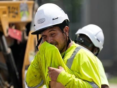 Construction worker Fernando Padilla wipes his face as he works in the heat, Friday, June 30, 2023 in Nashville, Tenn.