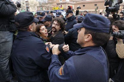 Policemen pull protestor Julia Alsinet out of the crowd at an escrache protest outside a PP deputy&rsquo;s home in Madrid last week.