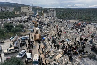 Civil defense workers and residents search through the rubble of collapsed buildings in the town of Harem near the Turkish border, Idlib province, Syria.