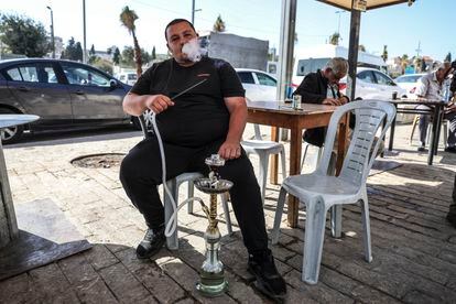 Un hombre fuma una pipa en la terraza de un local cercano a la Puerta de Damasco, este viernes en Jerusalén. 