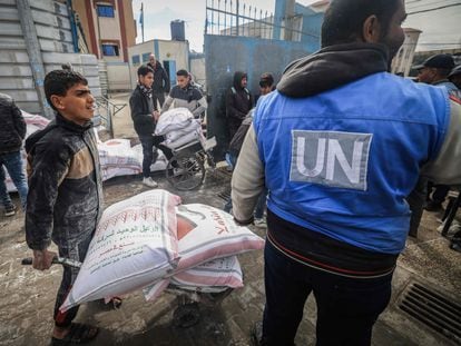 Palestinian UNRWA workers distribute flour to people displaced by the war in the southern city of Rafah, Gaza, on February 28, 2024.