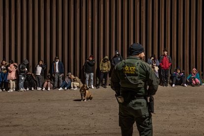 Immigrants wait to be processed by the US Border Patrol after crossing the border from Mexico in Arizona.