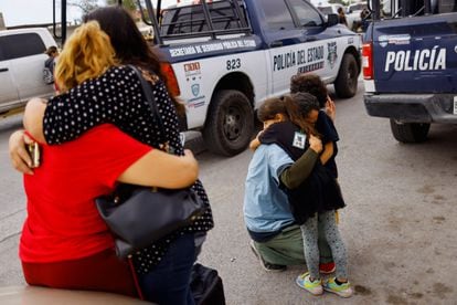 A man hugs his children, who were visiting a family member in prison when the riot began.