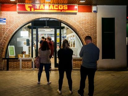 Customers wait in line outside a tobacconists in Pozuelo de Alarcón, Madrid on Friday ahead of planned store closures.