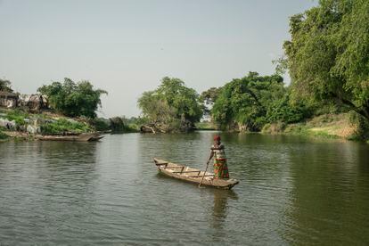 The river level near the village of Igbedor usually drops in January and February. This phenomenon causes sandy islets to resurface. Entire families settle on these islets for about two months, catching and drying fish to sell in local markets. In the photo, a woman paddles in the stretch of the river that separates the village from the agricultural fields. 
