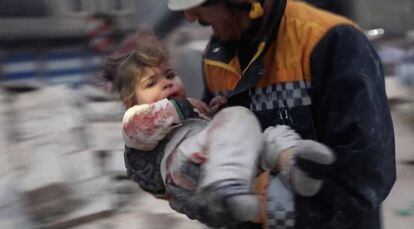 A rescuer carries an injured child away from the rubble of a building following an earthquake in rebel-held Azaz, Syria, in this still image taken from video. 