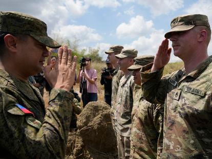 Philippine Army Artillery Regiment Commander Anthony Coronel returns a salute from a U.S. soldier during a joint military drill in northern Philippines, on March 31, 2023.