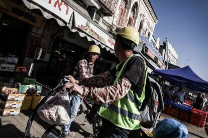Dos obreros de origen chino en una calle cercana a la Puerta de Damasco, este viernes en Jerusalén. 