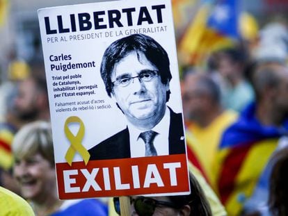 A pro-independence demonstrator holds up a Puigdemont sign.