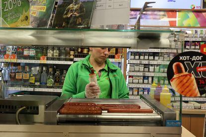 A gas station employee serves up a hot dog in Kyiv, in November of 2023.