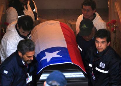 Workers remove former Chilean leader Salvador Allende's coffin from the family mausoleum in Santiago.
