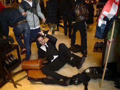 A security guard topples over as demonstrators invade a branch of Zara in Barcelona on Wednesday.