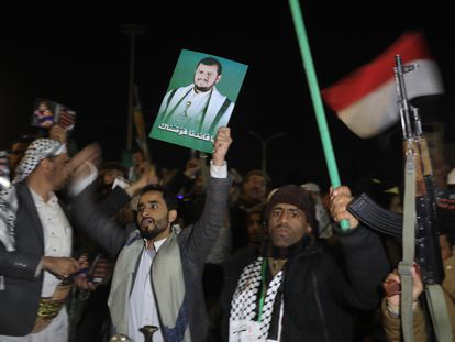 A Yemeni loyal to the Houthis holds up a poster depicting the top Houthi leader Abdul-Malik al-Houthi, during a gathering in support of Houthis' escalation against Israel, in Sana'a, Yemen, December 09 2023.