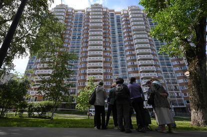 People look at a the apartment building in Moscow, Russia