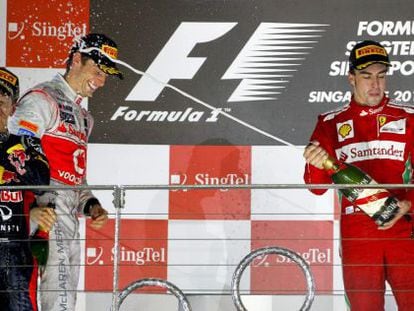 Fernando Alonso (right) sprays race winner Sebastian Vettel to Jenson Button&rsquo;s amusement. 