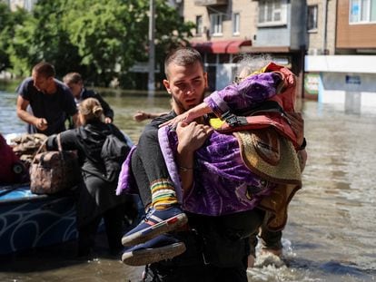 A rescue team evacuates a woman from the city of Kherson on Wednesday.