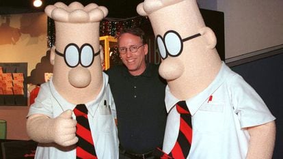 Scott Adams, the creator of "Dilbert", the cartoon character that lampoons the absurdities of corporate life, poses with two "Dilbert" characters at a party January 8, 1999 in Pasadena, Calif.