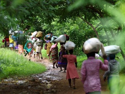 Flood victims from Mtauchira village carry food they received from the government in the aftermath of Cyclone Freddy that destroyed their homes in Blantyre, Malawi, March 16, 2023.