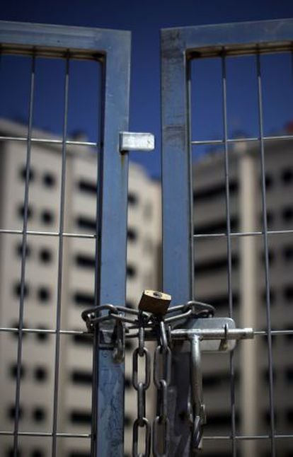 A chained gate blocks access to a new housing development in Madrid.