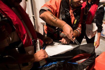 One of the crew cuts open a life preserver, which is revealed to be fake, on June 9.
