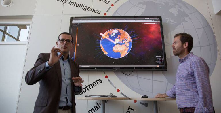 Incibe's rapid response team next to a screen showing real-time cyberattacks.