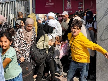 People walk through a gate to enter the Rafah border crossing to Egypt in the southern Gaza Strip on November 1, 2023.