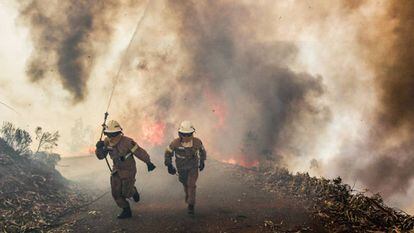 Firefighters flee the flames in Portugal.