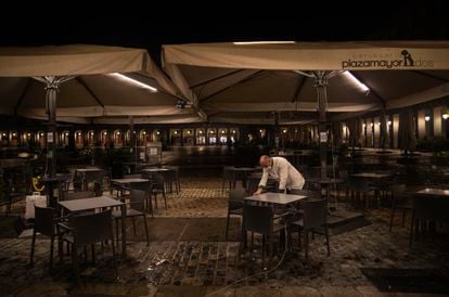 A waiter closes the terrace of a bar in Plaza Mayor, Madrid on Friday.