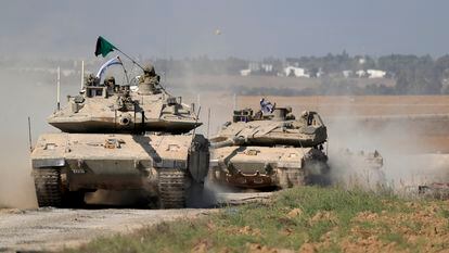 Merkava battle tanks of the Israel Defense Forces maneuver in an area along the border with Gaza, southern Israel, on October 13, 2023.