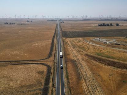 Traffic runs along Highway 113 in rural Solano County, Calif., with wind farms in the background Wednesday, Aug. 30, 2023.