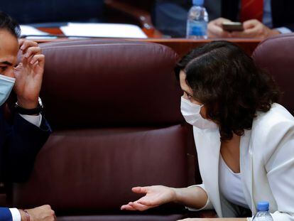 Madrid premier Isabel Díaz Ayuso (r) talks with her deputy Ignacio Aguado in the regional parliament.