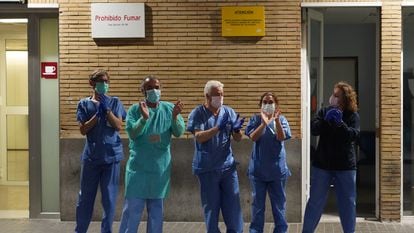 Health workers at a hospital in Seville applaud outside the emergency ward.