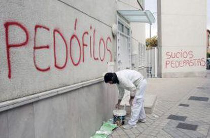 A cleaner removes spray paint on the walls of the Granada parish church whose priest is accused of abusing teenage altar boys.