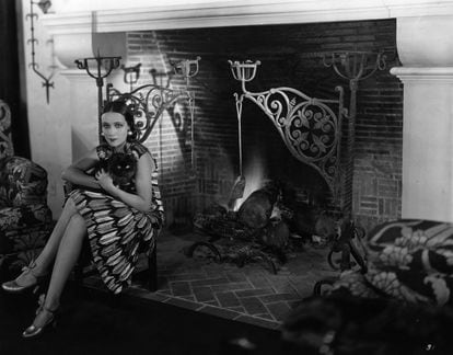 Dolores del Rio with her cat, Joan, in front of her home’s fireplace, “The biggest I’ve ever seen,” according to Grace Kingsley, the first Los Angeles Times film critic.