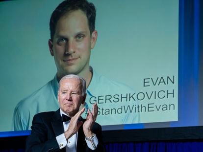 President Joe Biden applauds while standing in front of a sign calling for the release of Evan Gershkovich during the White House Correspondents' Association (WHCA) dinner in Washington, DC, US, on Saturday, April 29, 2023.