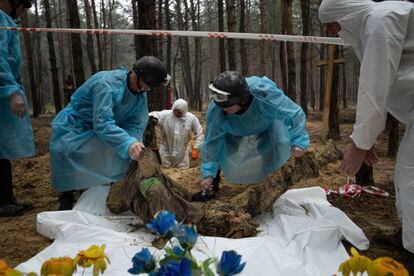 Emergency workers move the body of a Ukrainian soldier during an exhumation in the recently retaken area of Izium on Friday.