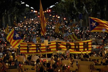 People hold a Catalan flag during candle-lit demonstration in Barcelona on October 17, 2017.